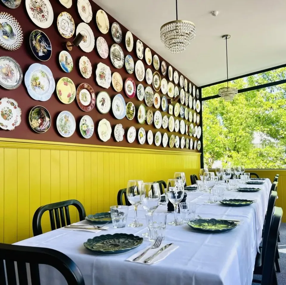 Private dining room with a long table and plates displayed on the wall